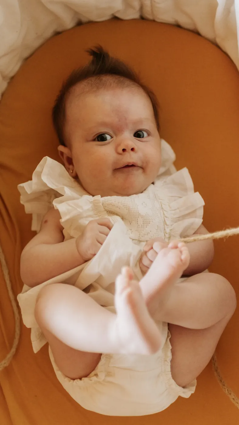 Bebê de roupa clara num cesto