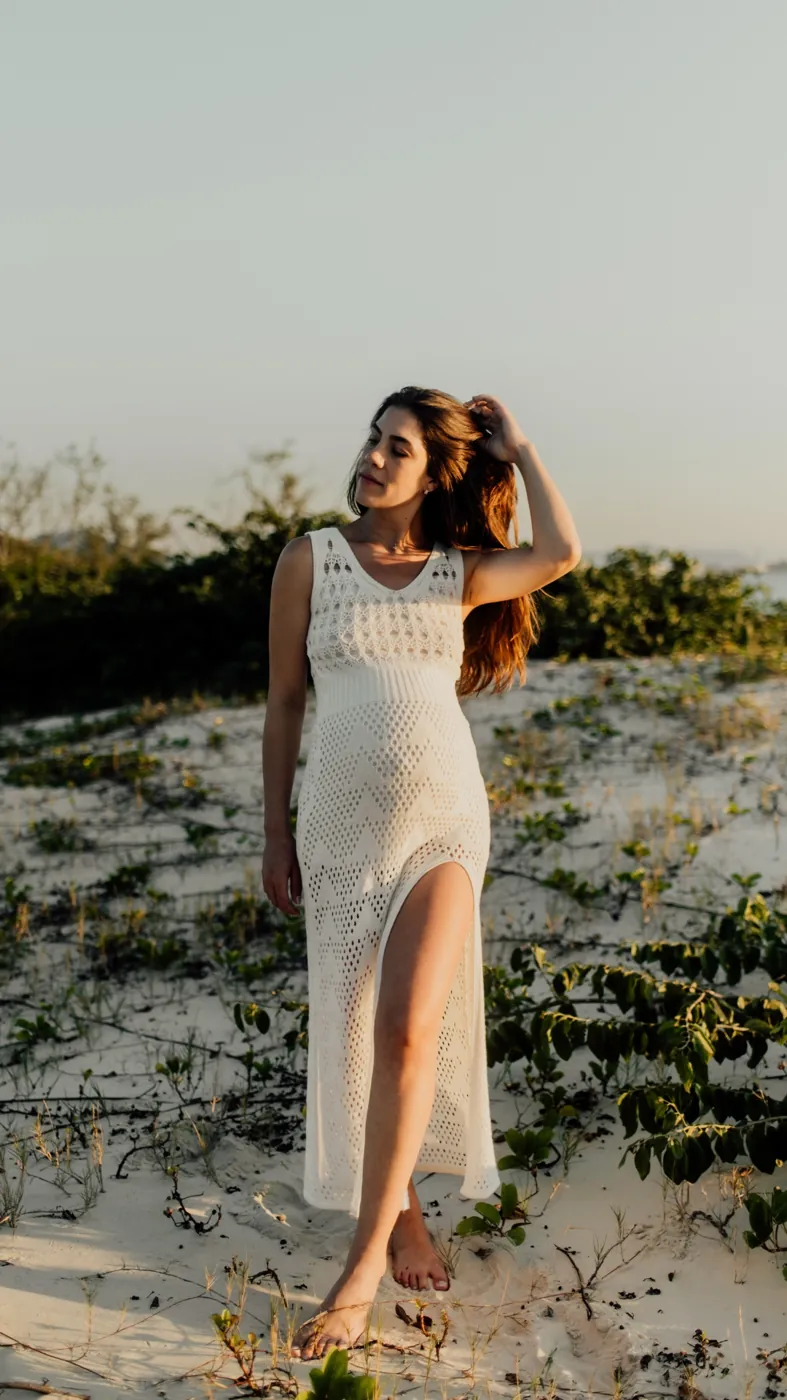 Gestante de vestido branco na restinga