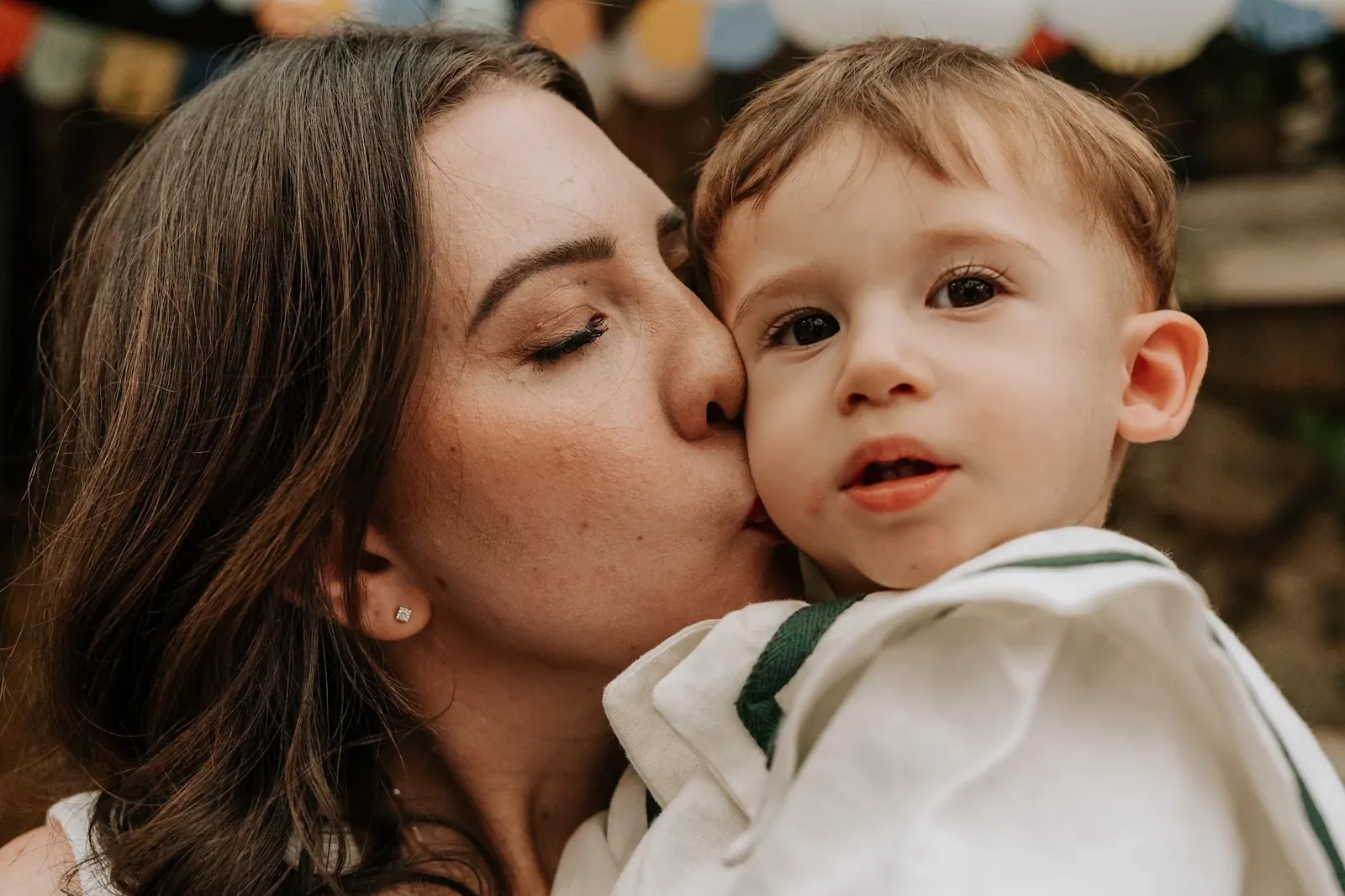 Mãe beija o bebê no primeiro aniversário